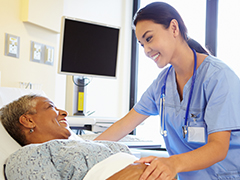 Speech Therapist Talking To Senior Woman In Hospital Room